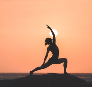 Warrior pose from yoga by woman silhouette on sunset
